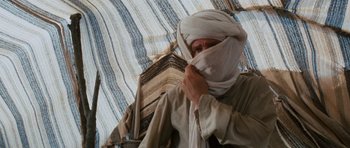 Movie still from “Raiders of the Lost Ark” (1981), directed by Steven Spielberg – A man with a turban covering his face; Medium shot, Low angle