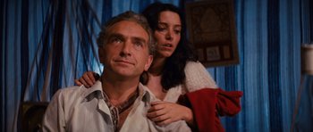 Movie still from “Raiders of the Lost Ark” (1981), directed by Steven Spielberg – A man and a woman are posing for a picture; Close Up shot, Low angle