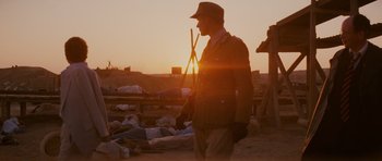 Movie still from “Raiders of the Lost Ark” (1981), directed by Steven Spielberg – A man standing in a field at sunset; Wide shot, Over the shoulder angle