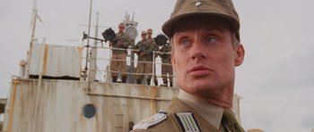 Movie still from “Raiders of the Lost Ark” (1981), directed by Steven Spielberg – A person wearing a uniform on a boat; Close Up shot, Low angle
