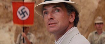 Movie still from “Raiders of the Lost Ark” (1981), directed by Steven Spielberg – A person wearing a hat; Close Up shot, Over the shoulder angle