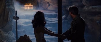 Movie still from “Raiders of the Lost Ark” (1981), directed by Steven Spielberg – A man and a woman holding hands at night; Wide shot, Over the shoulder angle