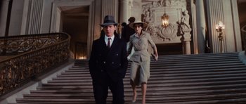 Movie still from “Raiders of the Lost Ark” (1981), directed by Steven Spielberg – A man and a woman are walking down the stairs; Wide shot, Low angle