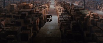 Movie still from “Raiders of the Lost Ark” (1981), directed by Steven Spielberg – A man is standing in a warehouse filled with wooden boxes; Extreme Wide shot, High angle