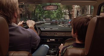 Movie still from “The Squid and the Whale” (2005), directed by Noah Baumbach – Two people in a car driving down a street; Medium shot, Over the shoulder angle