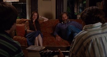 Movie still from “The Squid and the Whale” (2005), directed by Noah Baumbach – A man and woman sitting on a red couch; Wide shot, Over the shoulder angle