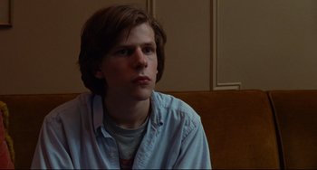 Movie still from “The Squid and the Whale” (2005), directed by Noah Baumbach – A man sitting in front of a wall looking to his left; Close Up shot, Over the shoulder angle