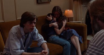 Movie still from “The Squid and the Whale” (2005), directed by Noah Baumbach – A group of people sitting on top of a brown couch; Medium shot, Over the shoulder angle