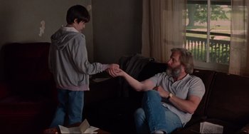 Movie still from “The Squid and the Whale” (2005), directed by Noah Baumbach – A man and a boy sitting on a couch holding hands; Medium shot, Over the shoulder angle