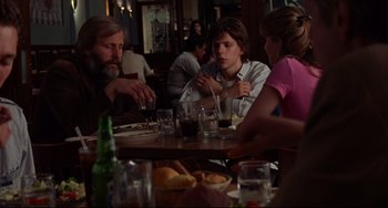 Movie still from “The Squid and the Whale” (2005), directed by Noah Baumbach – A group of people sitting at a table with drinks; Medium shot, Over the shoulder angle