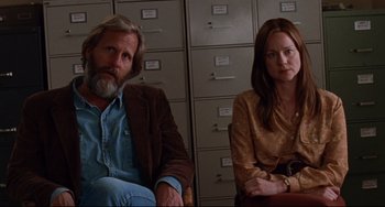 Movie still from “The Squid and the Whale” (2005), directed by Noah Baumbach – A man and a woman sitting next to each other in front of some filing cabinets; Medium shot, Low angle