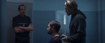 A man getting his hair cut by another man