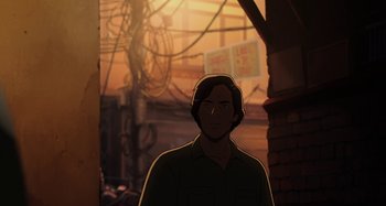 Movie still from “The Summit of the Gods” (2021), directed by Patrick Imbert – A man standing in front of a building with wires hanging from the ceiling; Medium shot, Low angle