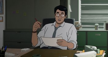 Movie still from “The Summit of the Gods” (2021), directed by Patrick Imbert – A man sitting at a desk holding a pen in his hand; Medium shot, High angle