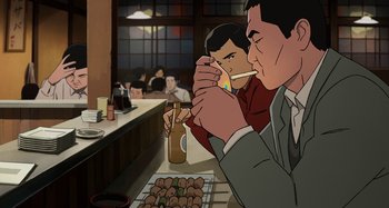 Movie still from “The Summit of the Gods” (2021), directed by Patrick Imbert – Two men sitting at a table eating food; Medium shot, Low angle