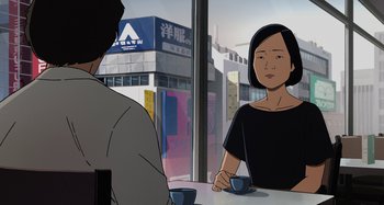 Movie still from “The Summit of the Gods” (2021), directed by Patrick Imbert – Two people are sitting at a table with cups of coffee; Medium shot, Over the shoulder angle