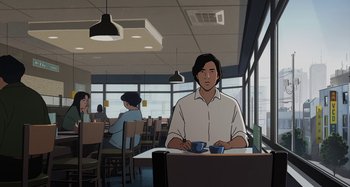 Movie still from “The Summit of the Gods” (2021), directed by Patrick Imbert – A man sitting at a table with a cup of coffee in front of him; Medium shot, Over the shoulder angle