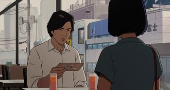 Movie still from “The Summit of the Gods” (2021), directed by Patrick Imbert – A man is looking at a woman in front of a mirror; Medium shot, Over the shoulder angle