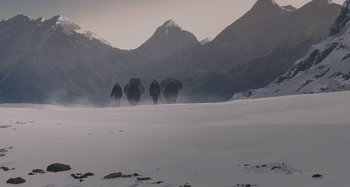 Movie still from “The Summit of the Gods” (2021), directed by Patrick Imbert – A group of people walking across a snow covered field; Extreme Wide shot, Low angle