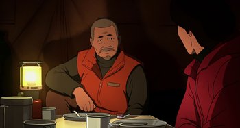 Movie still from “The Summit of the Gods” (2021), directed by Patrick Imbert – An older man sitting at a dinner table; Medium shot, Over the shoulder angle