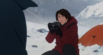 Movie still from “The Summit of the Gods” (2021), directed by Patrick Imbert – A man in a red jacket is taking a picture; Medium shot, Over the shoulder angle