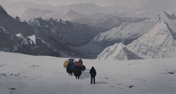 Movie still from “The Summit of the Gods” (2021), directed by Patrick Imbert – A man standing on top of a snow covered slope; Extreme Wide shot, Low angle