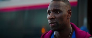 Movie still from “The Takedown” (2022), directed by Louis Leterrier – A man's face in a purple jacket; Close Up shot, Over the shoulder angle