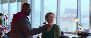 Movie still from “The Takedown” (2022), directed by Louis Leterrier – A man and a woman are standing in front of a window; Medium shot, Over the shoulder angle
