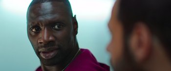 Movie still from “The Takedown” (2022), directed by Louis Leterrier – A man's face in front of another man; Close Up shot, Over the shoulder angle