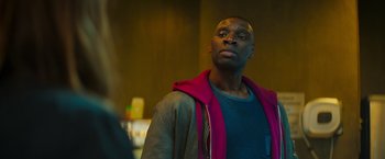 Movie still from “The Takedown” (2022), directed by Louis Leterrier – A man with a red jacket looking to his left; Close Up shot, Over the shoulder angle