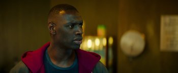 Movie still from “The Takedown” (2022), directed by Louis Leterrier – A person wearing a jacket; Close Up shot, Over the shoulder angle