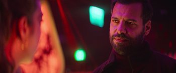 Movie still from “The Takedown” (2022), directed by Louis Leterrier – A man with a goatee is looking at the camera; Close Up shot, Over the shoulder angle