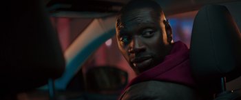 Movie still from “The Takedown” (2022), directed by Louis Leterrier – A person in a car; Close Up shot, Over the shoulder angle