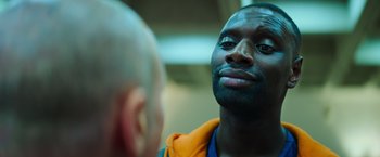 Movie still from “The Takedown” (2022), directed by Louis Leterrier – A person looking at another person; Close Up shot, Over the shoulder angle