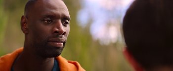 Movie still from “The Takedown” (2022), directed by Louis Leterrier – A person wearing an orange jacket; Close Up shot, Over the shoulder angle