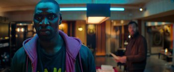 Movie still from “The Takedown” (2022), directed by Louis Leterrier – A person wearing a jacket; Close Up shot, Over the shoulder angle