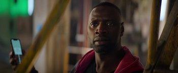 Movie still from “The Takedown” (2022), directed by Louis Leterrier – A person wearing a black shirt; Close Up shot, Low angle