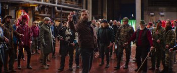 Movie still from “The Takedown” (2022), directed by Louis Leterrier – A group of people walking down a street; Wide shot, Over the shoulder angle