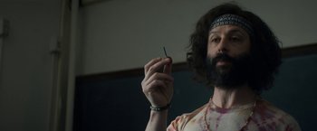 Movie still from “The Trial of the Chicago 7” (2020), directed by Aaron Sorkin – A man with a beard holding a tooth pick in his hand; Medium shot, Low angle
