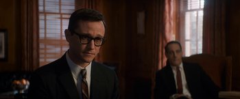 Movie still from “The Trial of the Chicago 7” (2020), directed by Aaron Sorkin – A man in a suit and tie in front of another man in a suit and tie; Medium shot, Over the shoulder angle