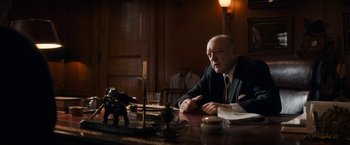 Movie still from “The Trial of the Chicago 7” (2020), directed by Aaron Sorkin – An older man sitting at a table in front of a candle; Medium shot, Over the shoulder angle