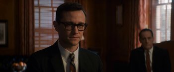 Movie still from “The Trial of the Chicago 7” (2020), directed by Aaron Sorkin – A man in a suit and tie wearing glasses; Close Up shot, Over the shoulder angle