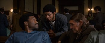 Movie still from “The Trial of the Chicago 7” (2020), directed by Aaron Sorkin – A group of men sitting around each other in a room; Medium shot, Over the shoulder angle