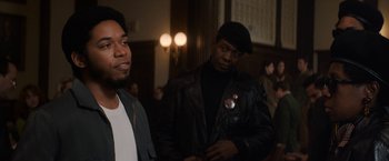 Movie still from “The Trial of the Chicago 7” (2020), directed by Aaron Sorkin – Two black men standing next to each other in a dark room; Medium shot, Over the shoulder angle