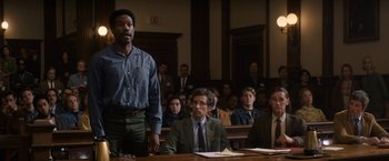 Movie still from “The Trial of the Chicago 7” (2020), directed by Aaron Sorkin – A man standing in front of a group of people in a courtroom; Medium shot, Low angle