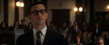 Movie still from “The Trial of the Chicago 7” (2020), directed by Aaron Sorkin – A man wearing a suit and tie in front of a group of people; Close Up shot, Low angle