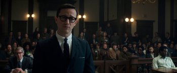 Movie still from “The Trial of the Chicago 7” (2020), directed by Aaron Sorkin – A man standing in front of a group of people in a courtroom; Medium shot, High angle