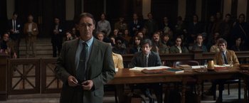 Movie still from “The Trial of the Chicago 7” (2020), directed by Aaron Sorkin – A man standing in front of a group of people in a courtroom; Medium shot, Over the shoulder angle