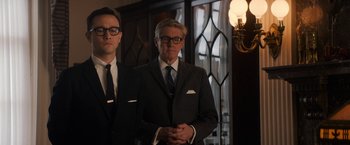 Movie still from “The Trial of the Chicago 7” (2020), directed by Aaron Sorkin – A man in a suit standing next to another man in a suit; Medium shot, Low angle