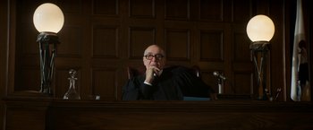 Movie still from “The Trial of the Chicago 7” (2020), directed by Aaron Sorkin – A judge sitting in front of a judge's bench; Medium shot, Low angle